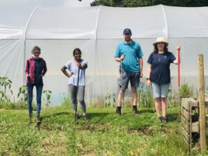 Day services group with garden tools standing in front of a poly tunnel at Ark at Egwood