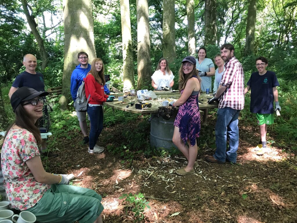 A group of people whittling wood in a copse