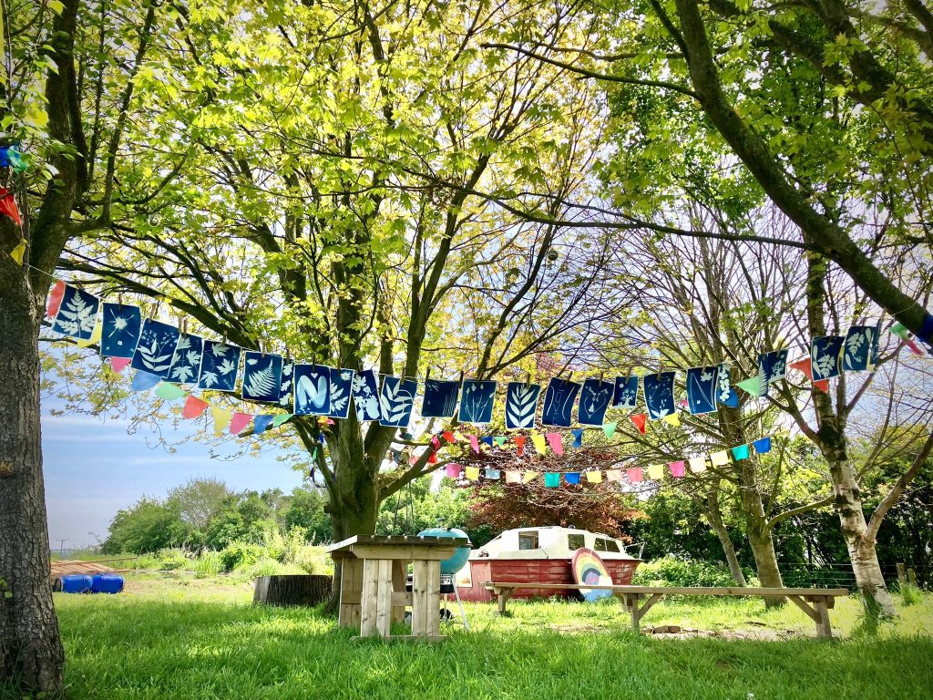 Bunting in a copse of trees with a boat on the grass behind